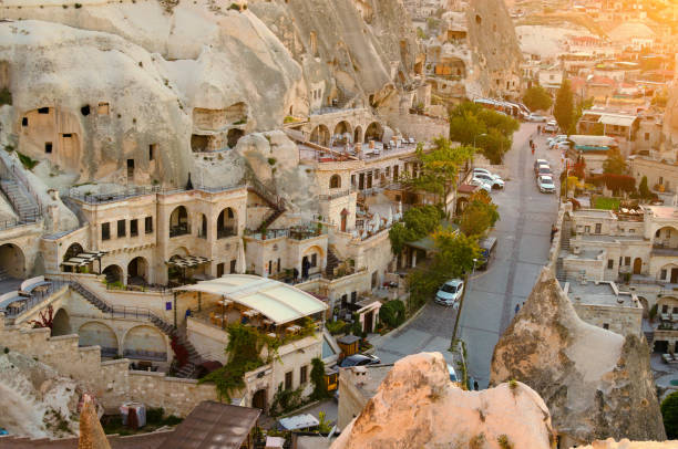 pitoresca vista paisagística do pôr do sol de antigas cavernas em goreme. destino de viagem popular na turquia. patrimônio mundial da unesco - goreme rural scene sandstone color image - fotografias e filmes do acervo