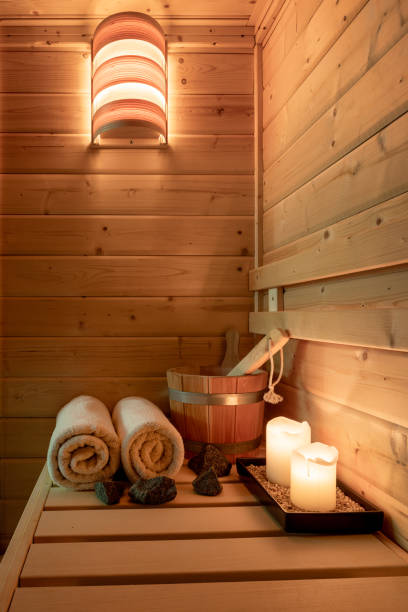 intérieur d’un petit sauna finlandais en bois avec accessoires de sauna - sauna health spa healthy lifestyle wellbeing photos et images de collection