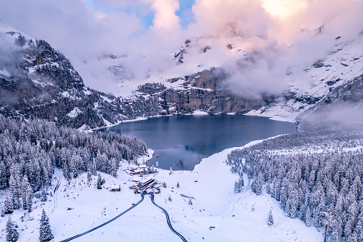 Oeschinen Lake sits high in the Swiss Mountains with a depth of 54 meters is accessible by hiking or ski lift. It freezes over in the winter and is popular with swimming, ice skating and fishing.
