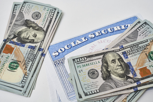 Social security card and us dollars cash money on white. Social security benefits. Concept of social security benefits payment, retirement and federal government benefits