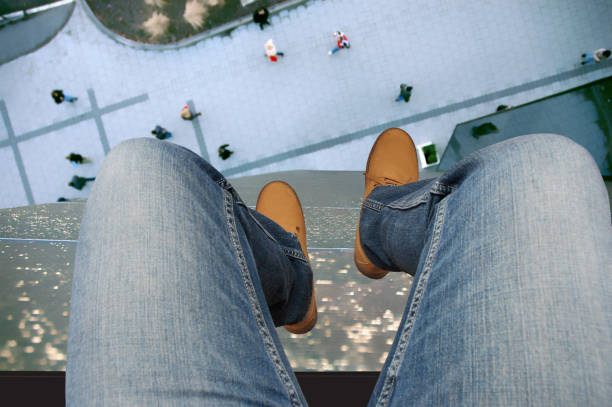 intento suicida al saltar: el enfoque principal está en los zapatos para lograr una sensación de altura de construcción peligrosa y profundidad borrosa. - falling suicide men built structure fotografías e imágenes de stock