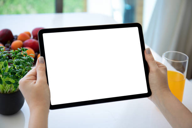 istock female hands holding computer tablet with isolated screen background fruits 1357507050