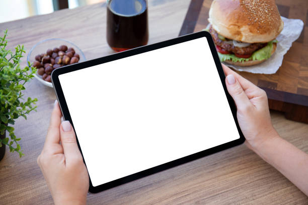mains féminines tenant une tablette d’ordinateur avec un fond d’écran isolé burger - electronic organizer palmtop women personal data assistant photos et images de collection