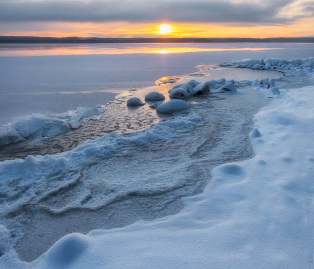 istock lake bound by ice and snow at sunset in winter 1357509283