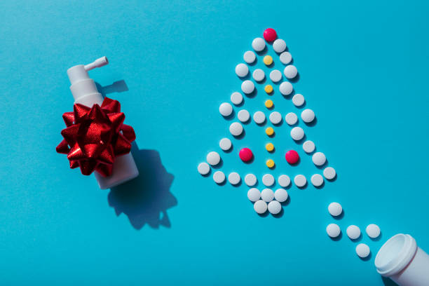 Creative Christmas tree made of pills on a blue background with nasal spray, prescription for sick people on holidays. stock photo