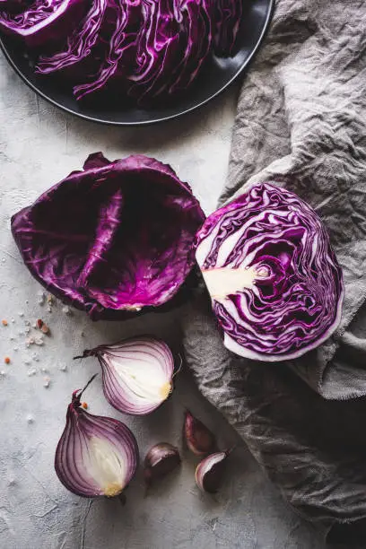 Top view of a red cabbage with red onion and garlic on a light grey background