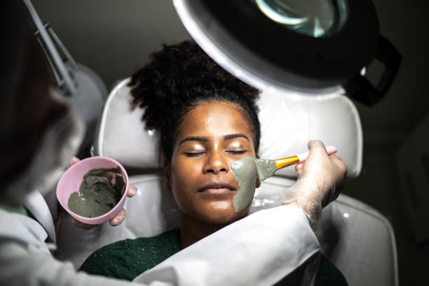 Young woman doing a facial treatment at a spa Young woman doing a facial treatment at a spa facial chemical peel stock pictures, royalty-free photos & images