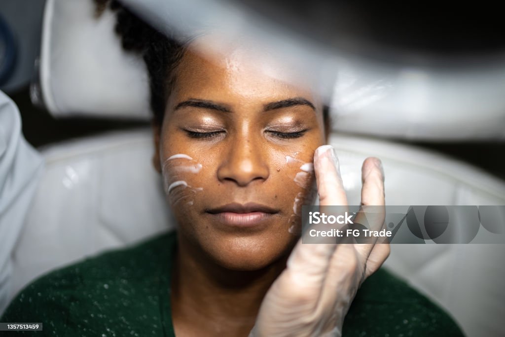 Young woman doing a facial treatment at a spa Aesthetician Stock Photo