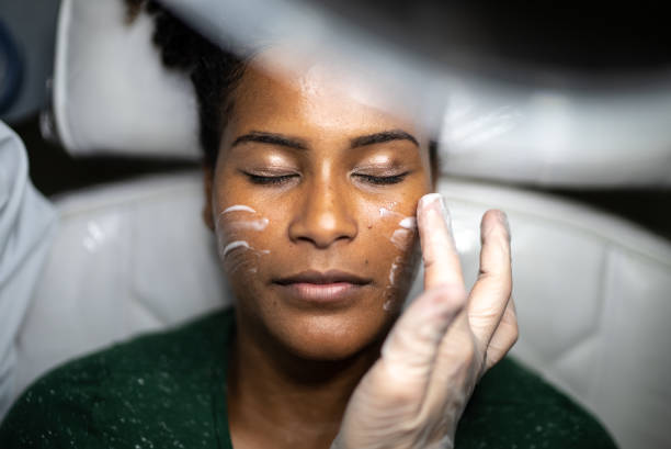 Young woman doing a facial treatment at a spa Young woman doing a facial treatment at a spa aesthetician photos stock pictures, royalty-free photos & images