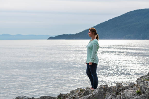 istock Female hiker relaxes on coastal mountain ridge 1357516348