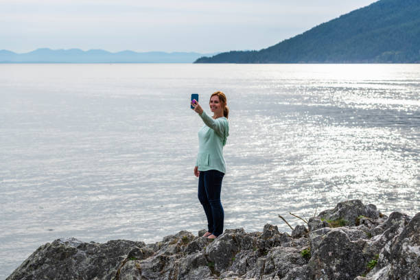 istock Female hiker relaxes on coastal mountain ridge 1357516361