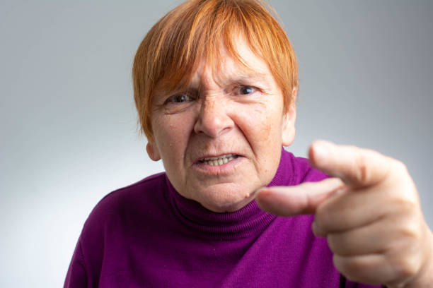 portrait of senior woman yelling and pointing - behavior women anger pointing imagens e fotografias de stock