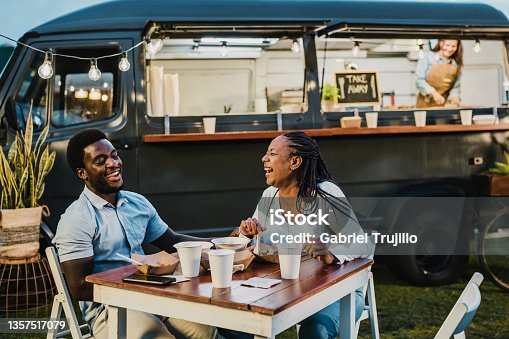 istock Happy black couple laughing during dinner near food truck 1357517079