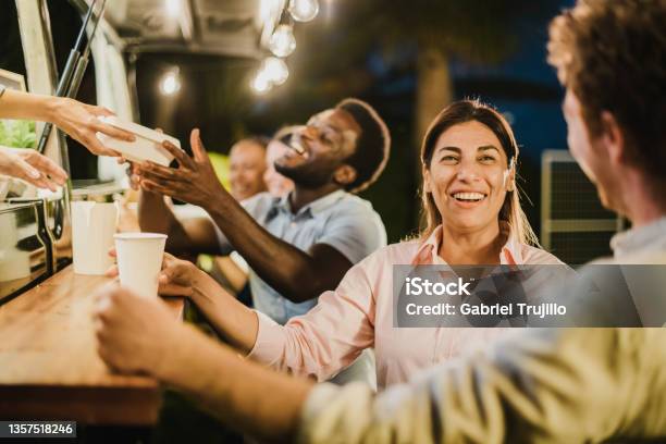 Hispanic Woman Speaking With Friend Outside Food Truck Stock Photo - Download Image Now