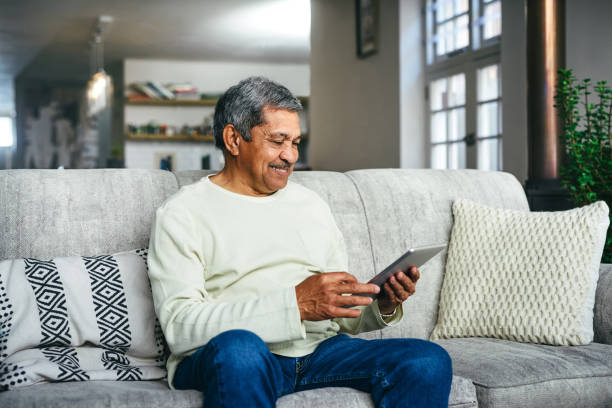 istock Shot of a senior man using a digital tablet on the sofa at home 1357522212