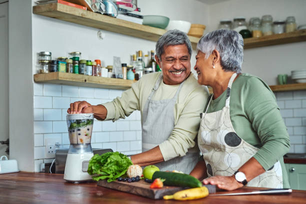 shot of a senior couple preparing a healthy smoothie in the kitchen at home - healthy food imagens e fotografias de stock
