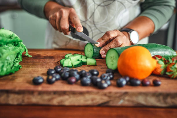 Shot of an unrecognisable senior man cooking a healthy meal at home All the colours of the vitamin rainbow chopping food stock pictures, royalty-free photos & images