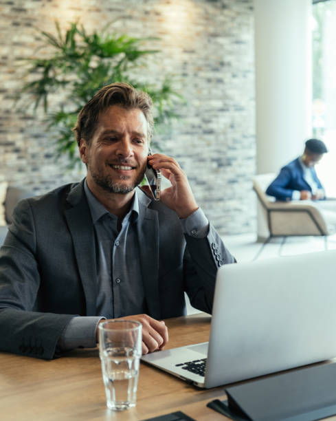 istock Happy Business Man Talking on a Mobile Phone at Work 1357522637