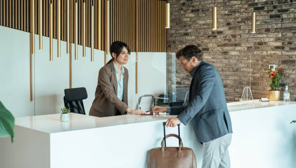 istock Female Hotel Receptionist Assisting Businessman for Checking In 1357522641