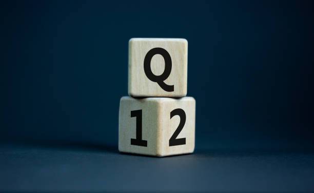 From 1st to 2nd quarter symbol. Turned wooden cubes and changed words 'Q1' to 'Q2'. Beautiful grey table, grey background. Business, happy 2nd quarter Q2 concept, copy space. stock photo