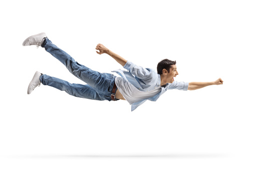 Casual young man in jeans flying isolated on white background