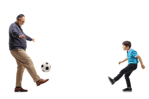 полнометражный профильный снимок дедушки и мальчика, играющих в футбол - ball indoors lifestyles sport стоковые фото и изображения