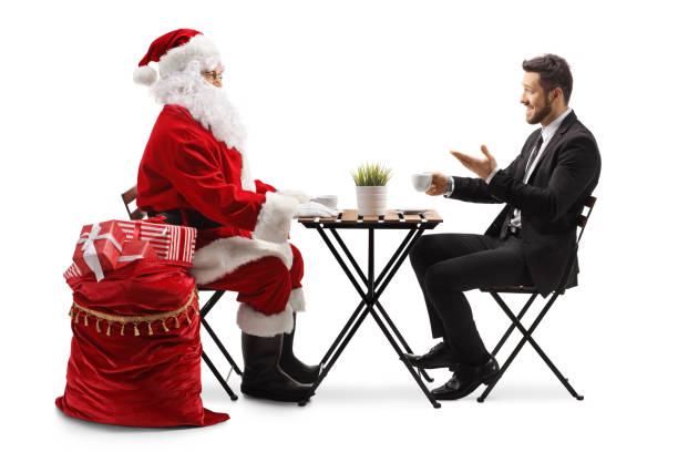 der weihnachtsmann und ein geschäftsmann unterhalten sich an einem cafétisch - communication discussion coffee christmas stock-fotos und bilder