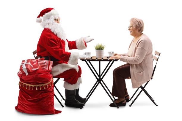 der weihnachtsmann und eine ältere frau trinken kaffee an einem cafétisch und unterhalten sich - communication discussion coffee christmas stock-fotos und bilder