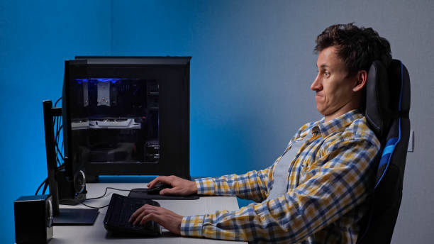 пристрастившись к играм, человек играет постоянно сидя за компьютером - complimentary gratis freedom computer keyboard стоковые фото и изображения