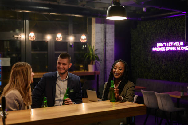 istock Cheerful colleagues toasting in the bar together after work 1357523470
