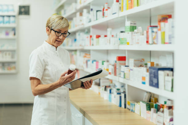 istock Beautiful senior female pharmacist checking medications on a shelf 1357523476