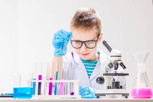 istock A schoolboy with a microscope examines chemicals in test tubes, conducts experiments - a portrait on a white background. Concept for the study of coronavirus in the laboratory 1357523724