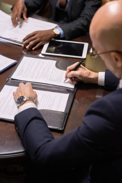 istock Mature businessman putting his signature on juridical document 1357524826