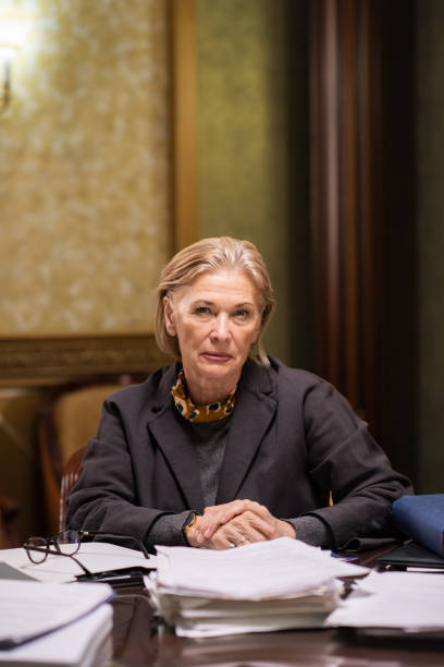 istock Confident mature female lawyer looking at you while sitting by workplace 1357524851