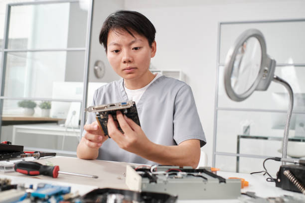 istock Young serious female specialist checking motherboard or part of computer hardware 1357525239
