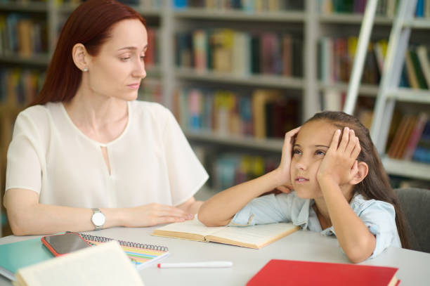 istock Sad girl and young woman studying at table 1357525307