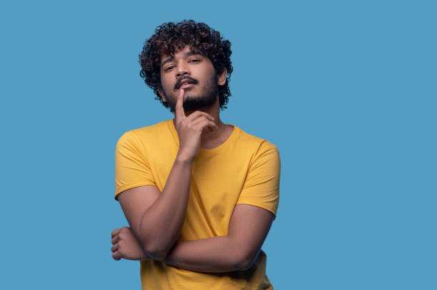 istock Calm relaxed guy touching his face with the forefinger 1357525769