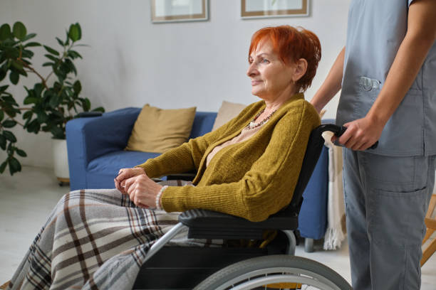 istock Elderly woman using wheelchair with nurse 1357525994
