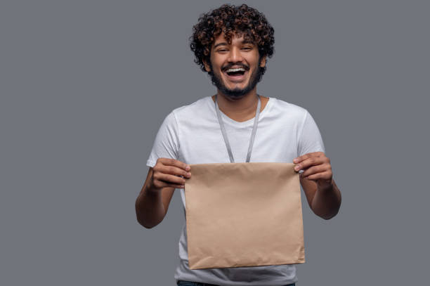 istock High-spirited deliveryman holding the package with both hands before him 1357526062