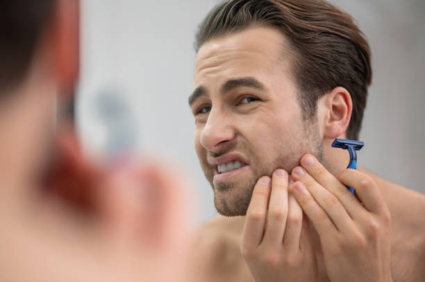 istock Young man shaving and looking disturbed 1357526118