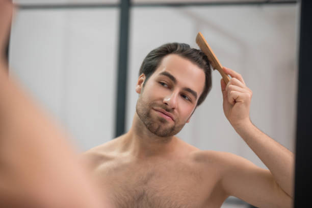 istock Young handsome man brushing his hair and looking contented 1357526125
