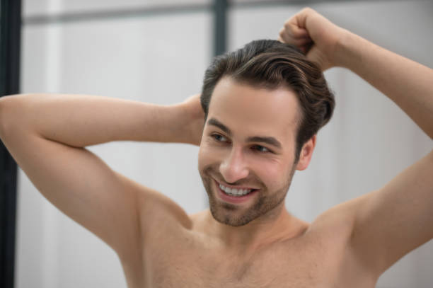 istock Young handsome man brushing his hair and looking contented 1357526139