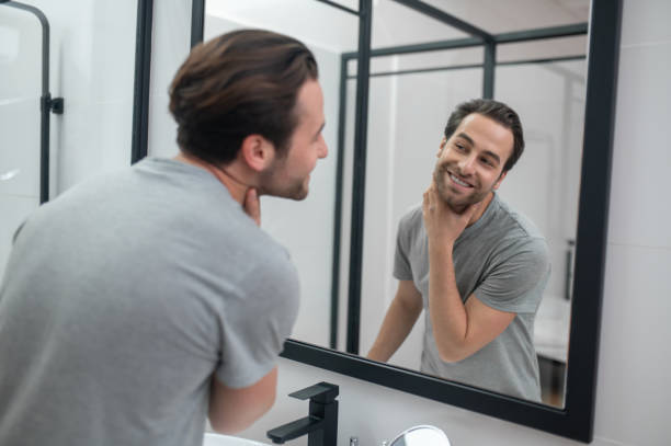 istock Man near the mirror scrutinizing himself 1357526159