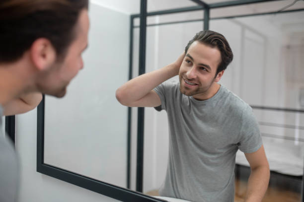 istock Man near the mirror scrutinizing himself 1357526167
