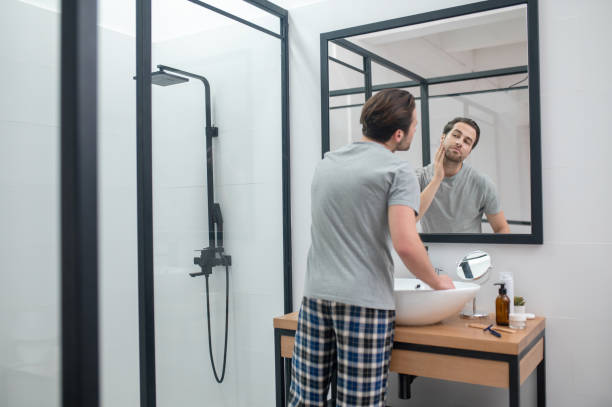 istock Man near the mirror scrutinizing himself 1357526172