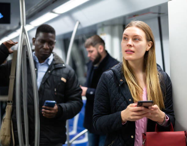 istock Young woman browsing on phone in metro car 1357526235