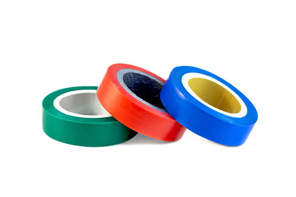 istock Red, green and blue adhesive insulating electrical tape reels stack isolated on white background 1357526384