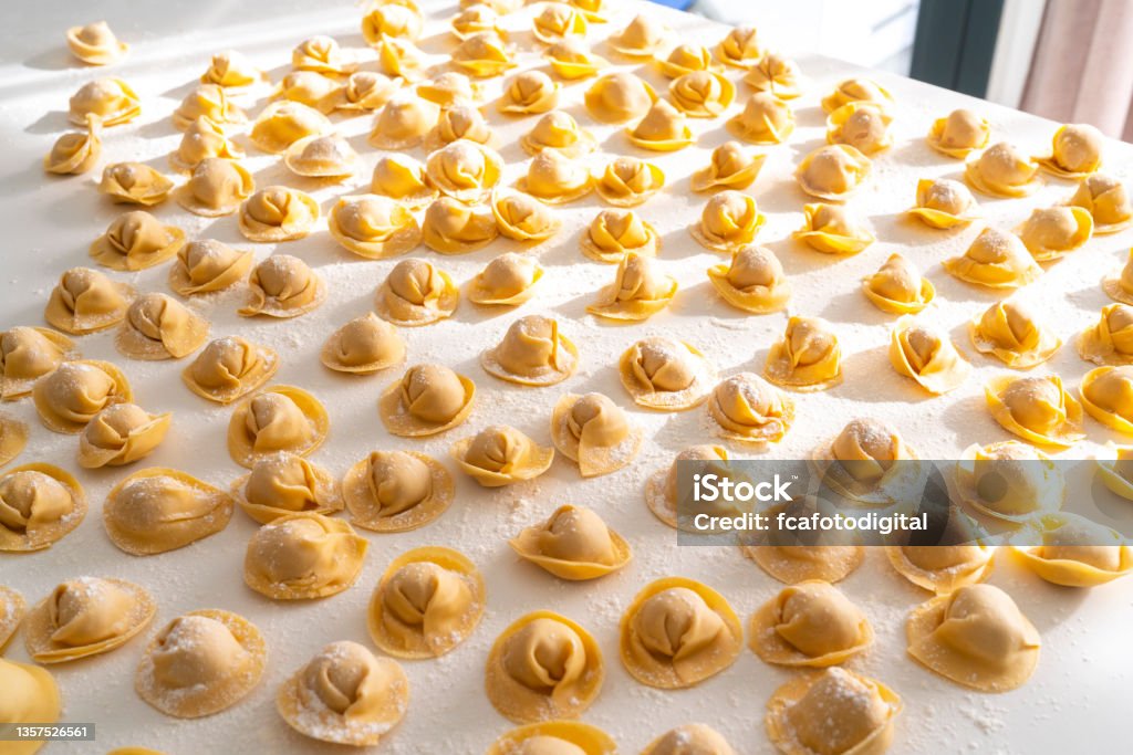 Italian cappelletti pasta on kitchen counter Traditional Italian food: Large group of raw Italian cappelletti pasta shot on white kitchen countertop. High resolution 42Mp studio digital capture taken with SONY A7rII and Zeiss Batis 40mm F2.0 CF lens Artisanal Food and Drink Stock Photo