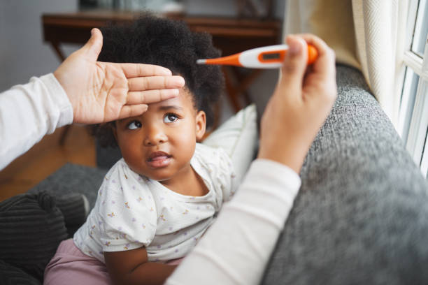 istock Shot of an unrecognizable mother checking her daughter's temperature at home 1357526856