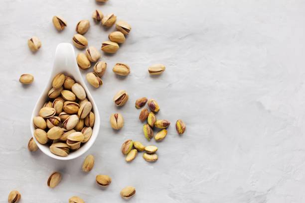 istock A white plate with rav pistachios in a shelll on a grey background 1357527529